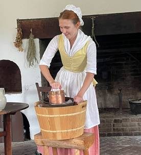 woman hand churning ice cream in 18th century clothing